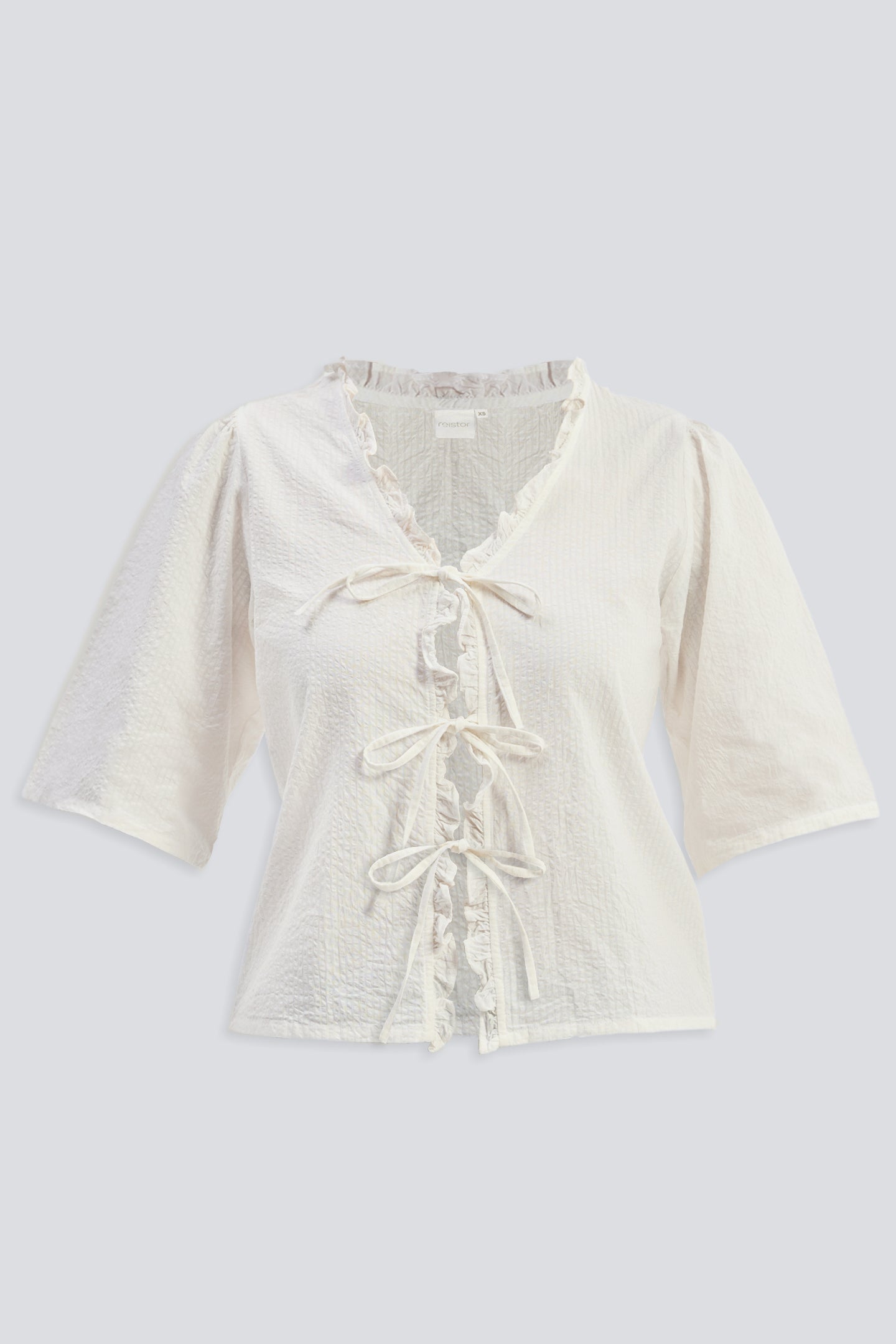Top de corte relajado con volantes y lazos delanteros en color crema