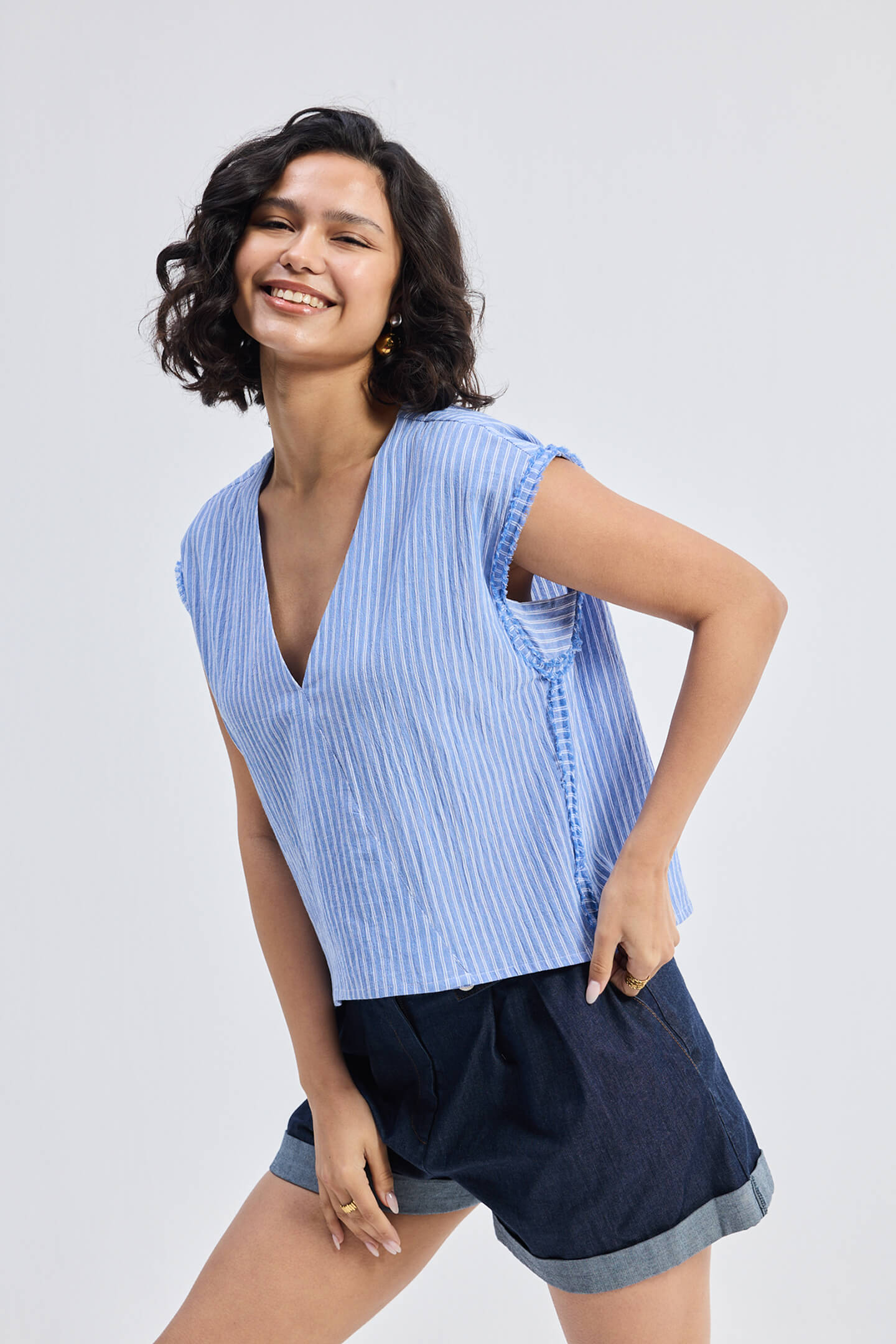 Top amplio con cuello de pico y detalle deshilachado