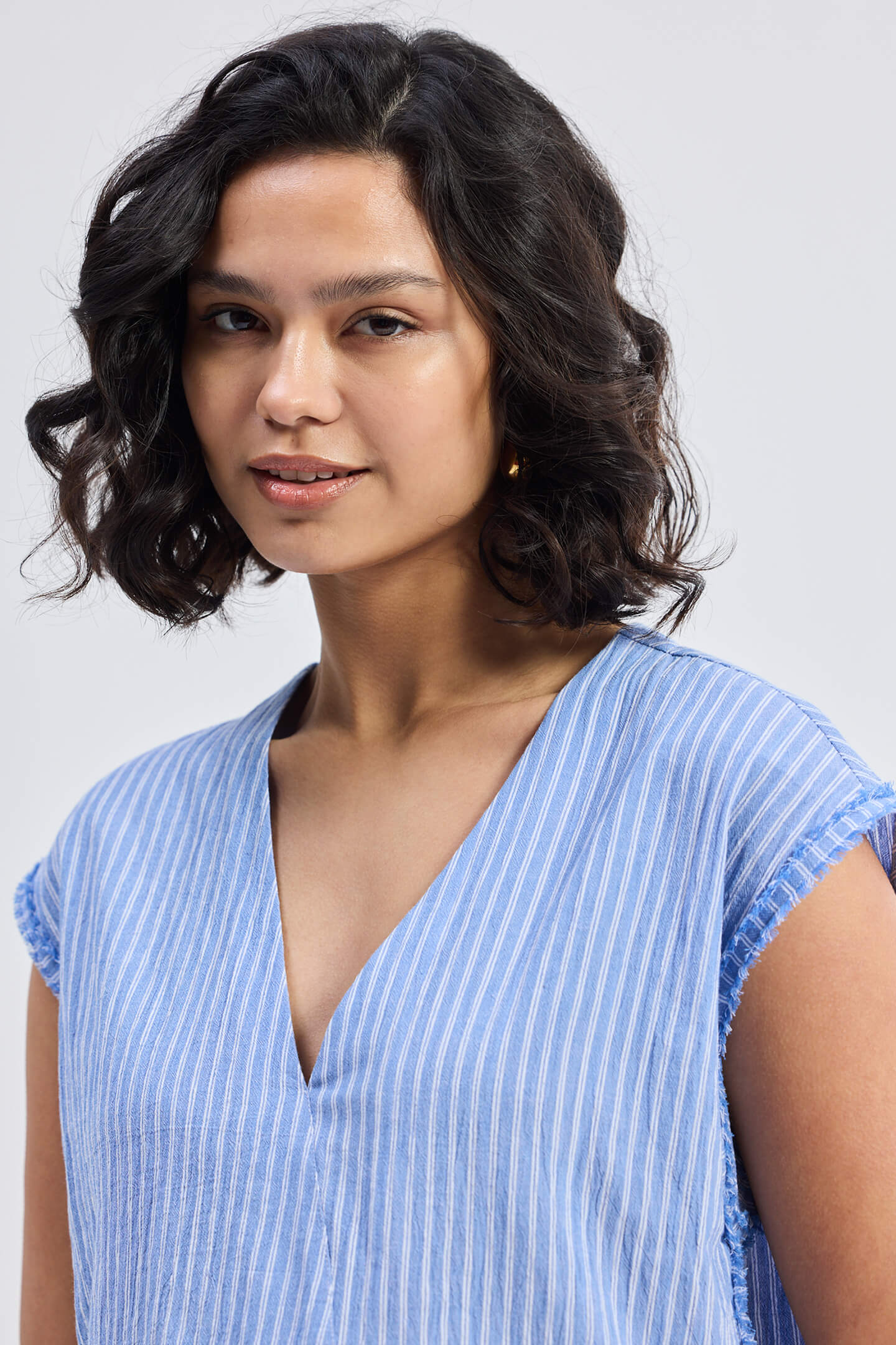 Top amplio con cuello de pico y detalle deshilachado