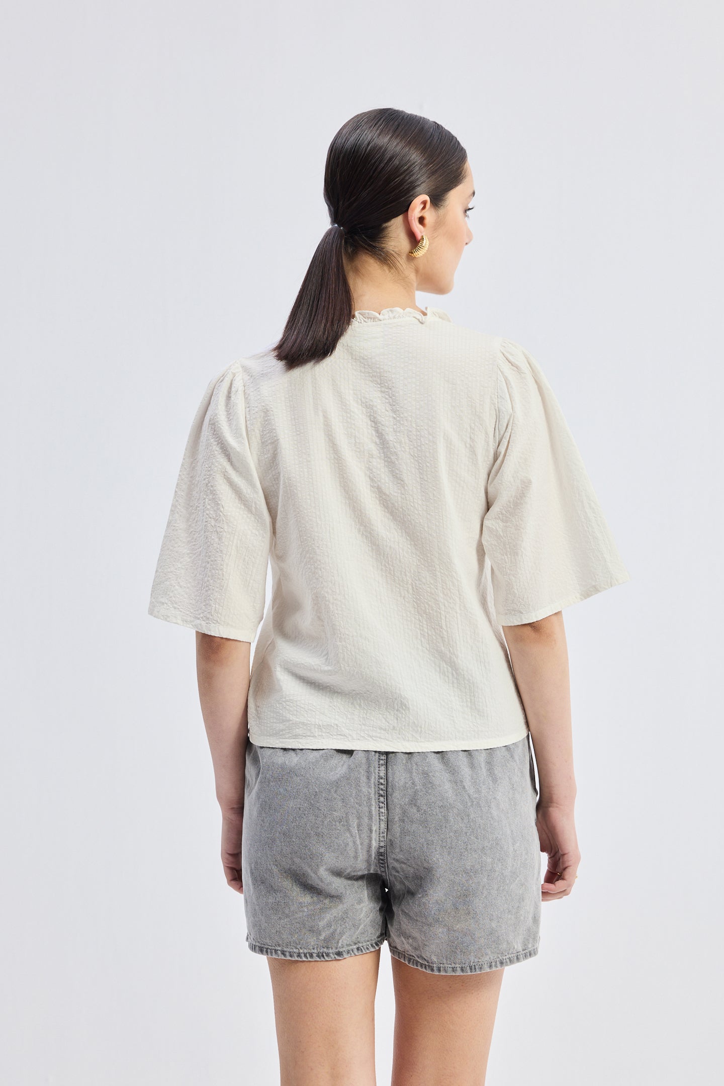 Top de corte relajado con volantes y lazos delanteros en color crema