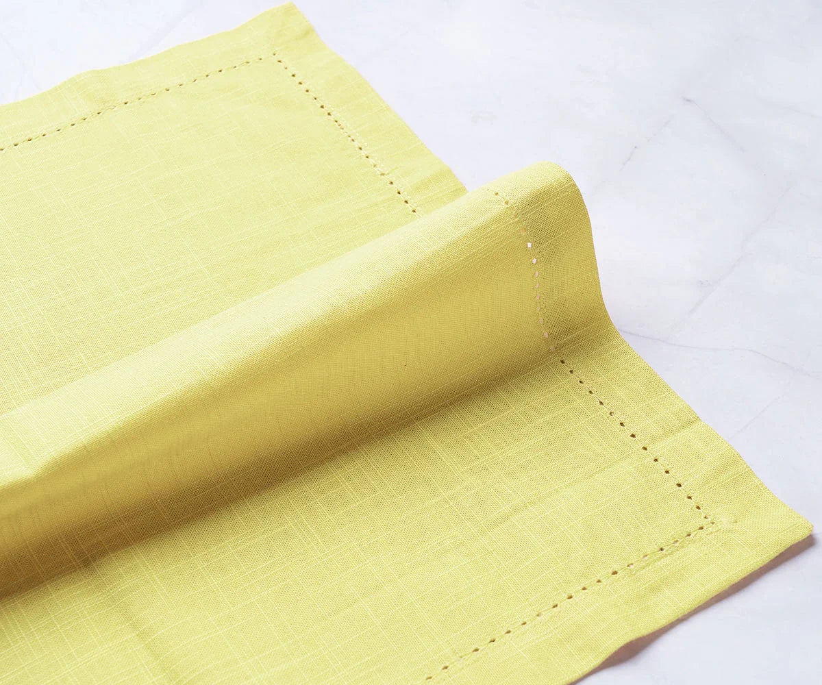 Servilletas de color amarillo mantequilla con dobladillo