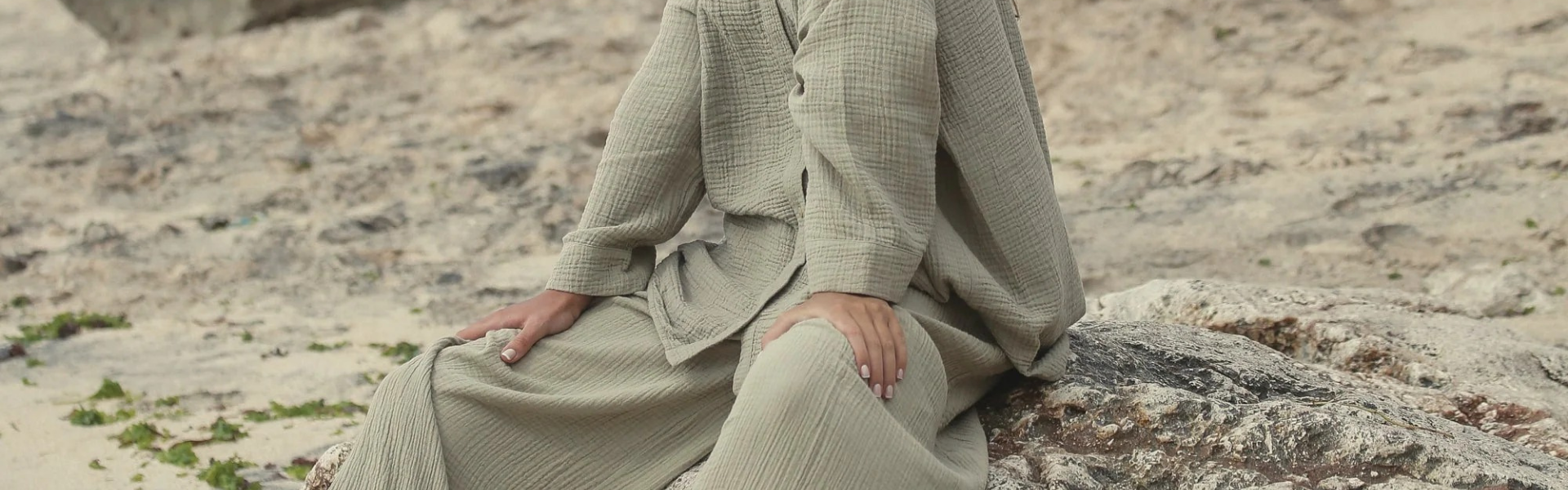 Woman sitting outfoors wearing soft loungewear set in natural light 