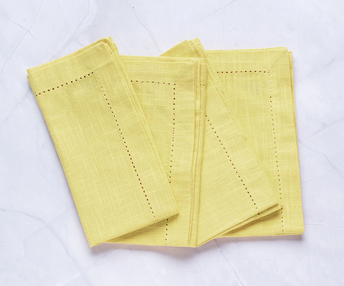 Servilletas de color amarillo mantequilla con dobladillo